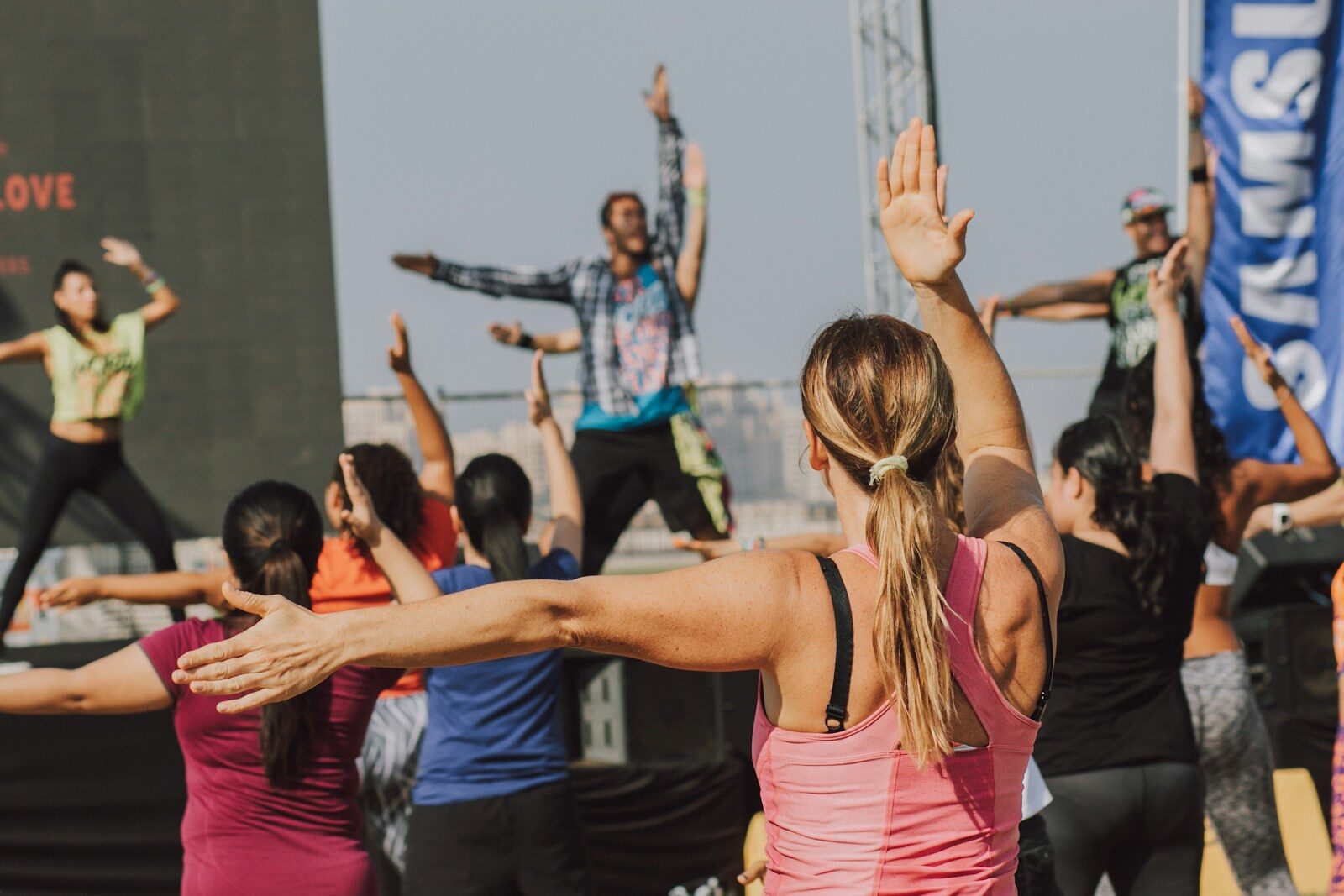 woman in pink tank top raising her hands